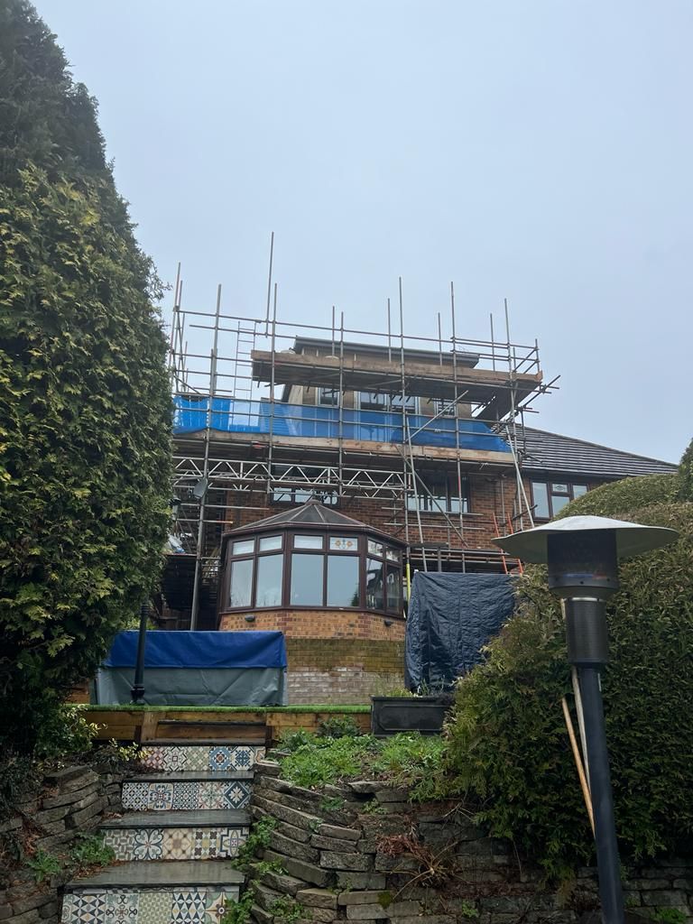 a house with scaffolding around it and stairs leading up to it .