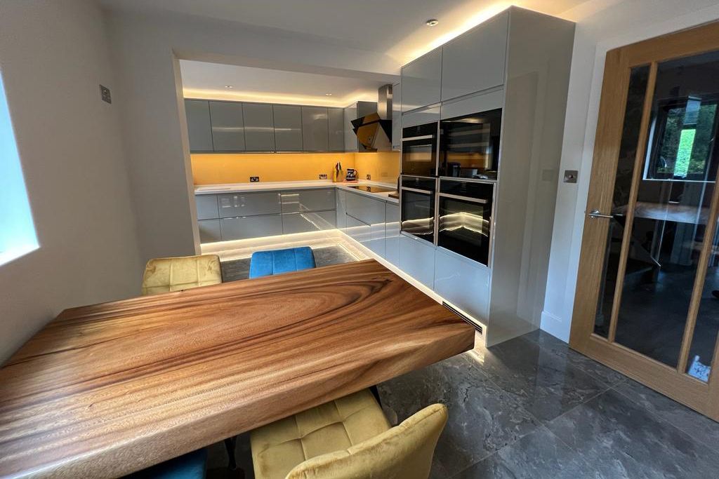 a kitchen with a wooden table and chairs in it .