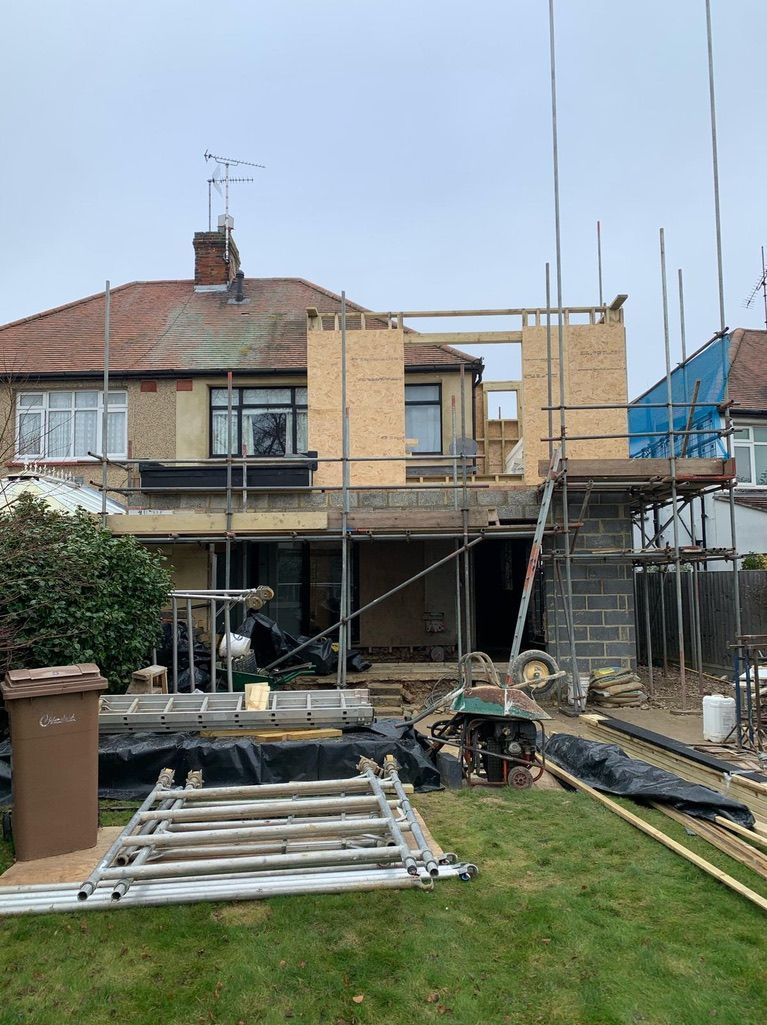 a house is being built with scaffolding in the backyard .