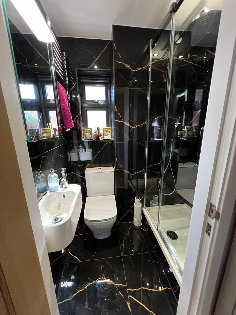 a bathroom with a toilet , sink and shower .