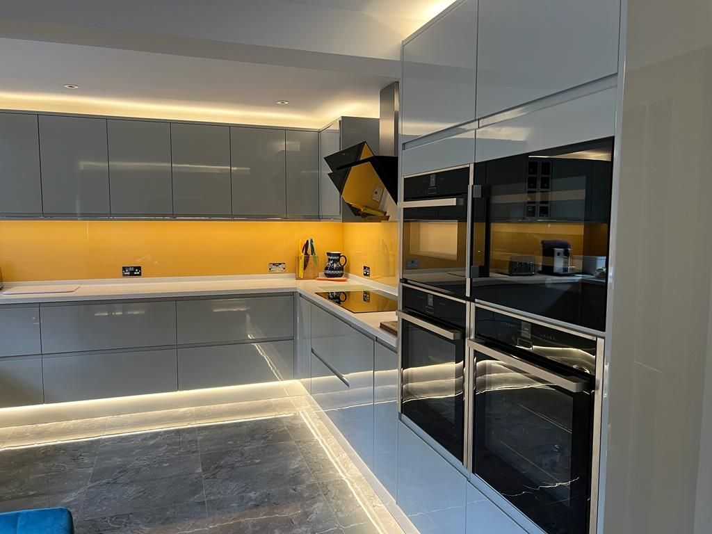 a kitchen with gray cabinets and black appliances
