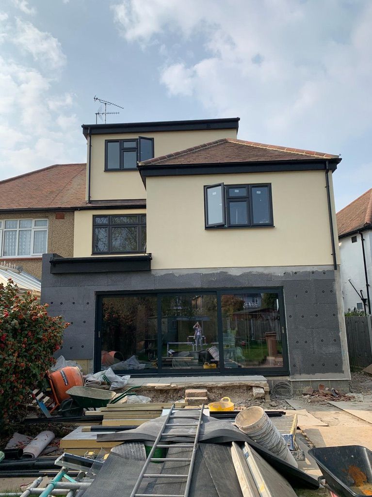 the back of a house is being built with a ladder in the foreground .