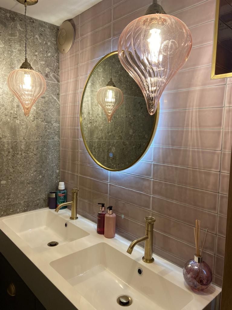 a modern bathroom with one sink and a round mirror .