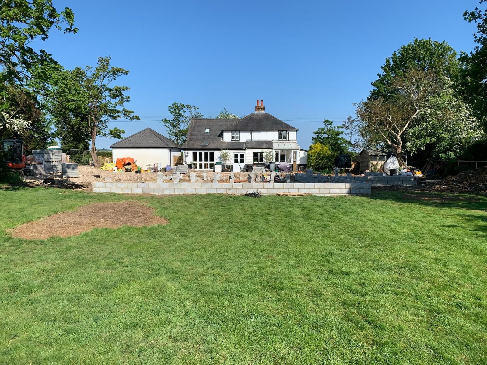 a large house is being built in the middle of a lush green field .