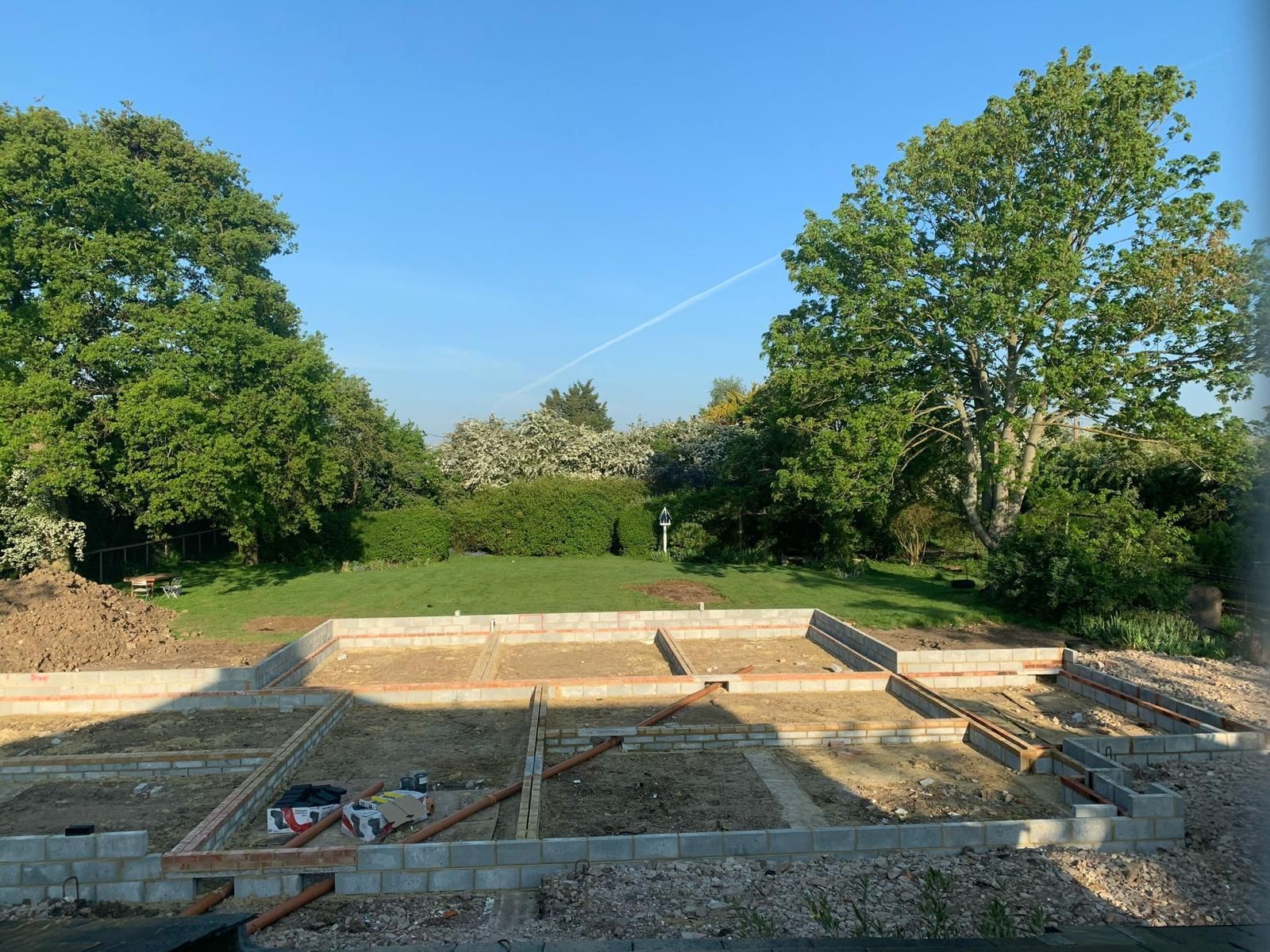 a construction site with trees in the background and a blue sky .