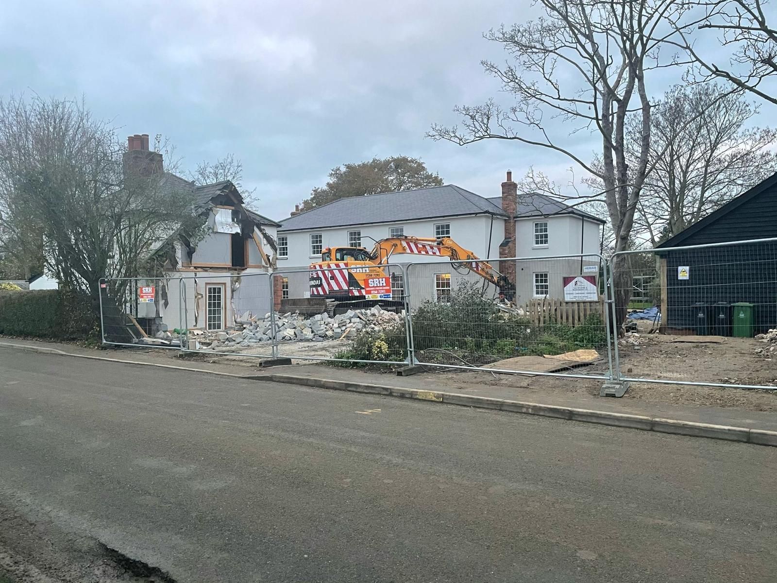 a large house is being demolished on the side of the road .