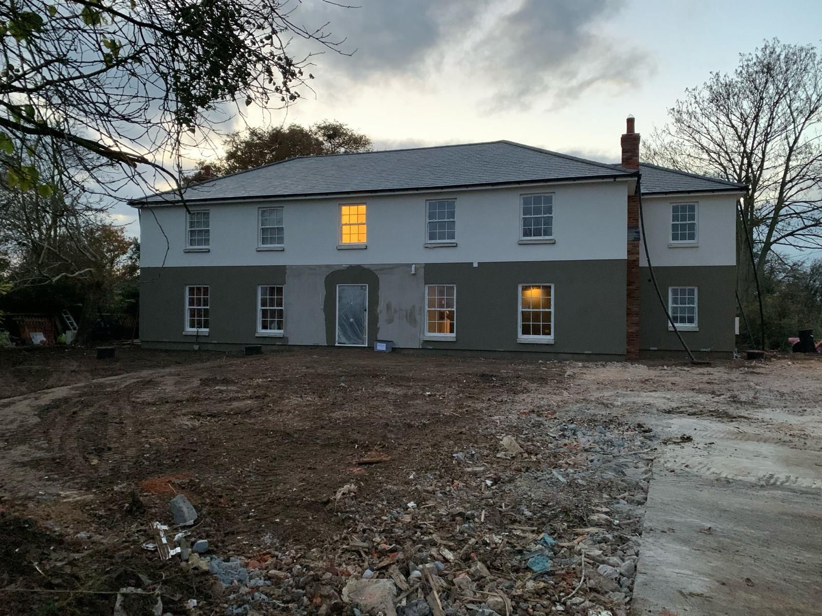 a large house with a lot of windows and a lot of dirt in front of it