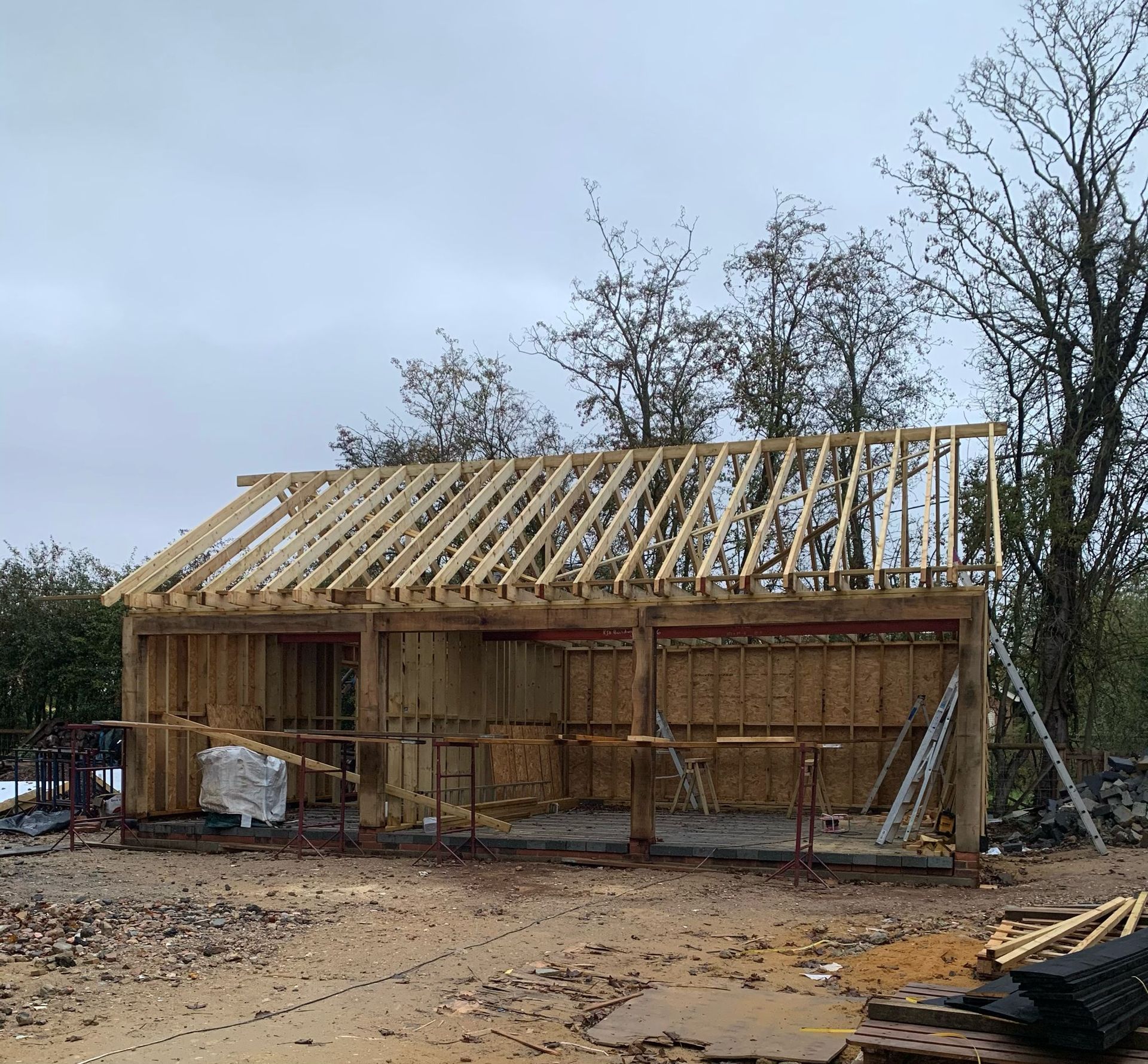 a small wooden house is being built in the middle of a dirt field .
