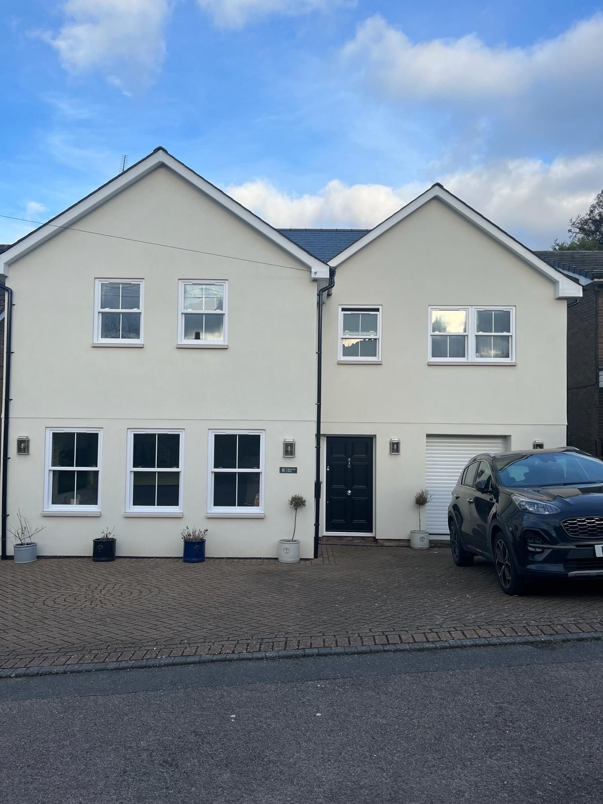 a white house with a black car parked in front of it