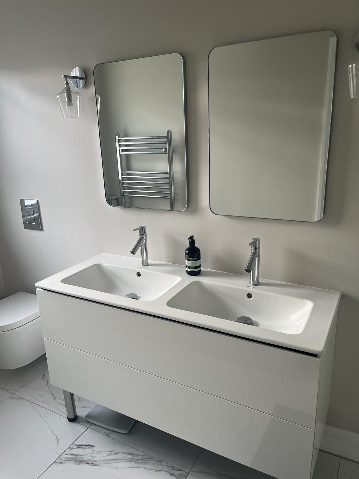 a bathroom with two sinks and two mirrors .