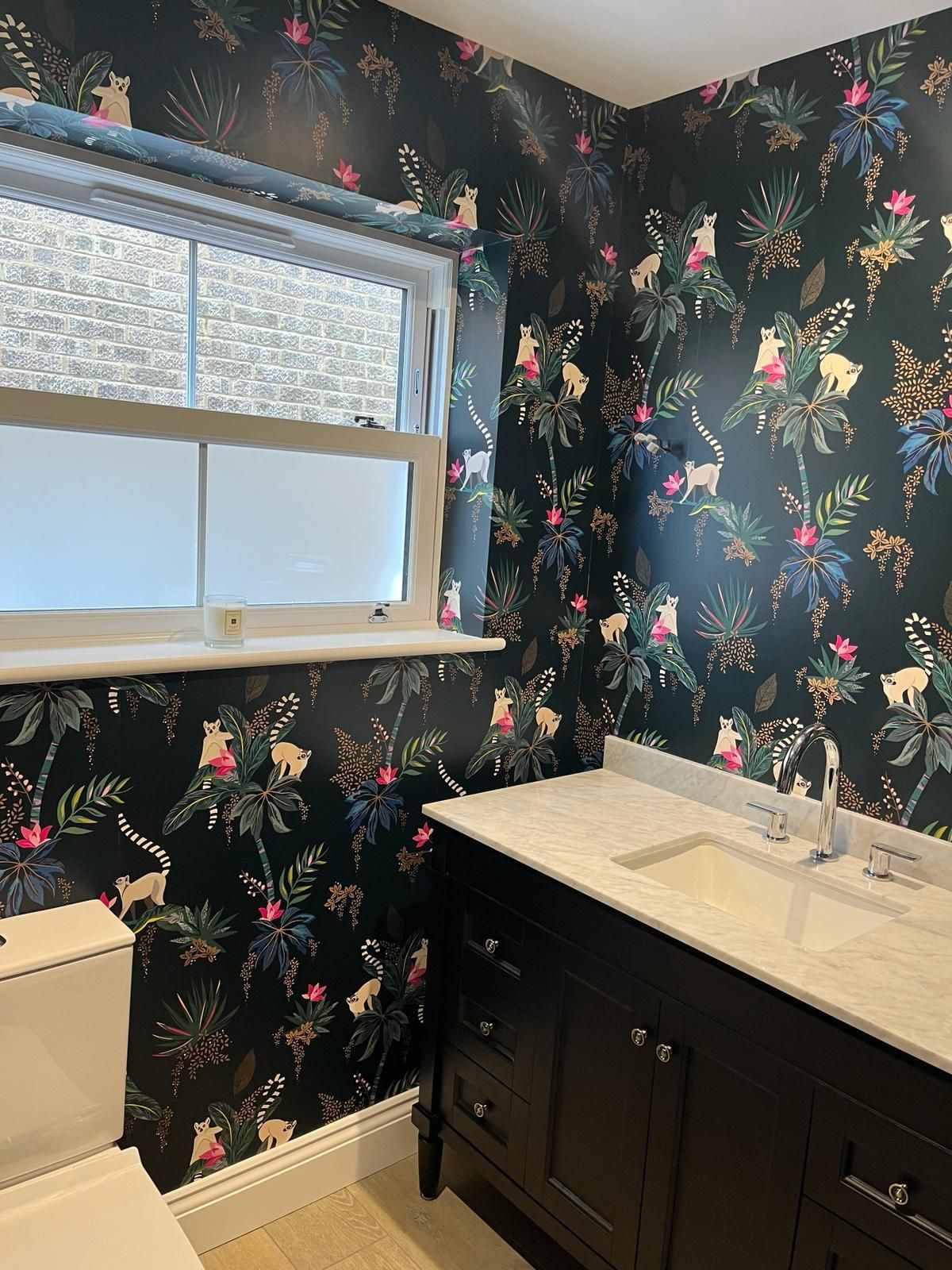 a bathroom with a sink , toilet , and window .