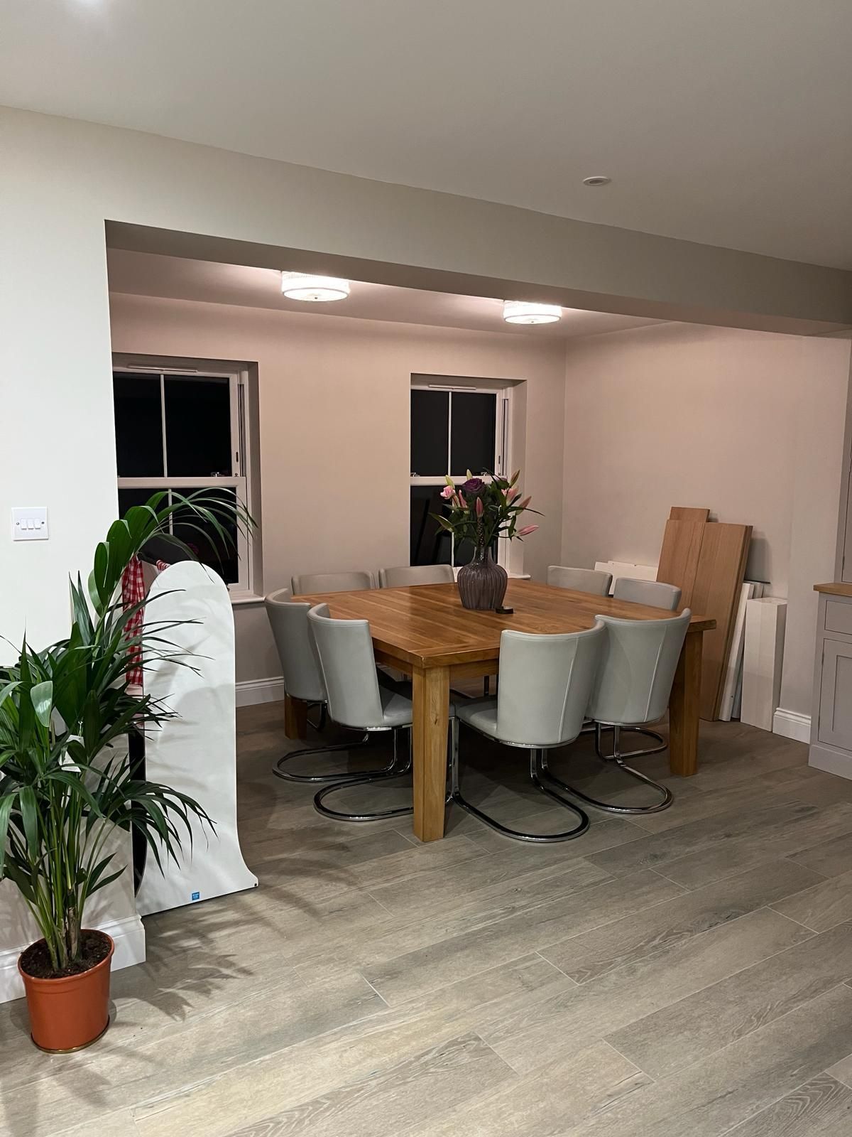a dining room with a wooden table and white chairs .
