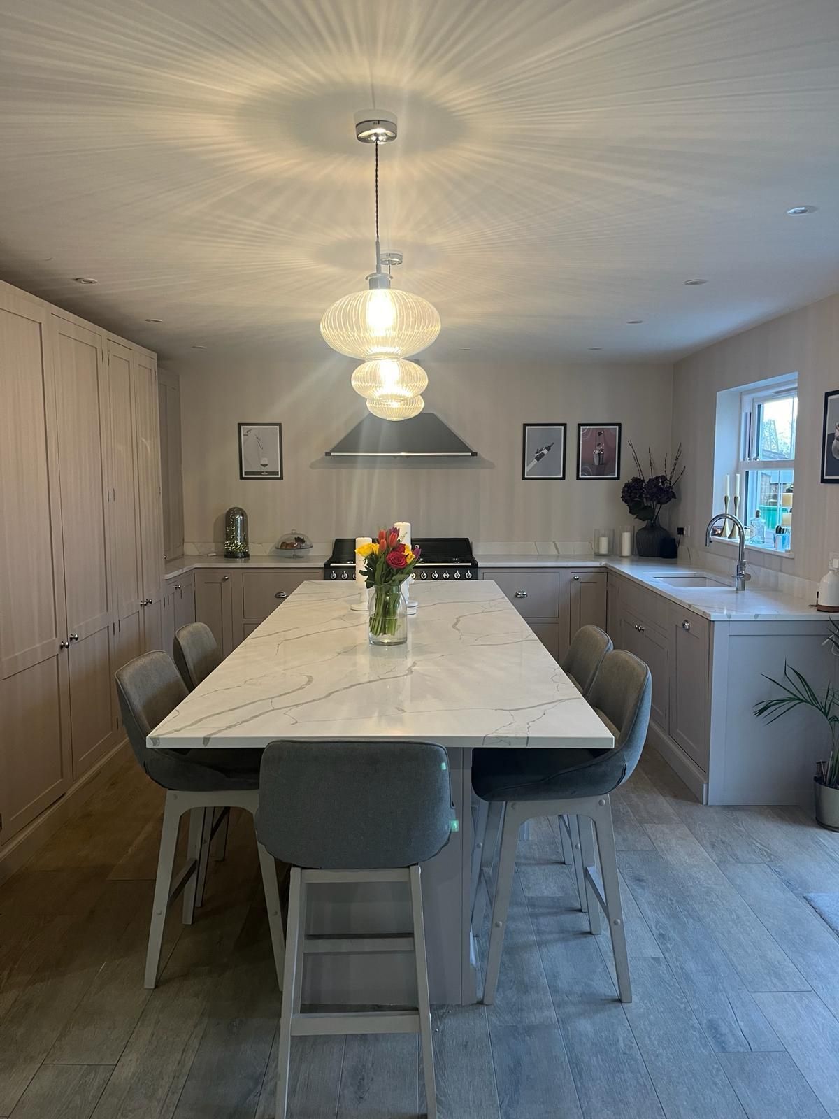 a kitchen with a long table and chairs and a vase of flowers on the table .