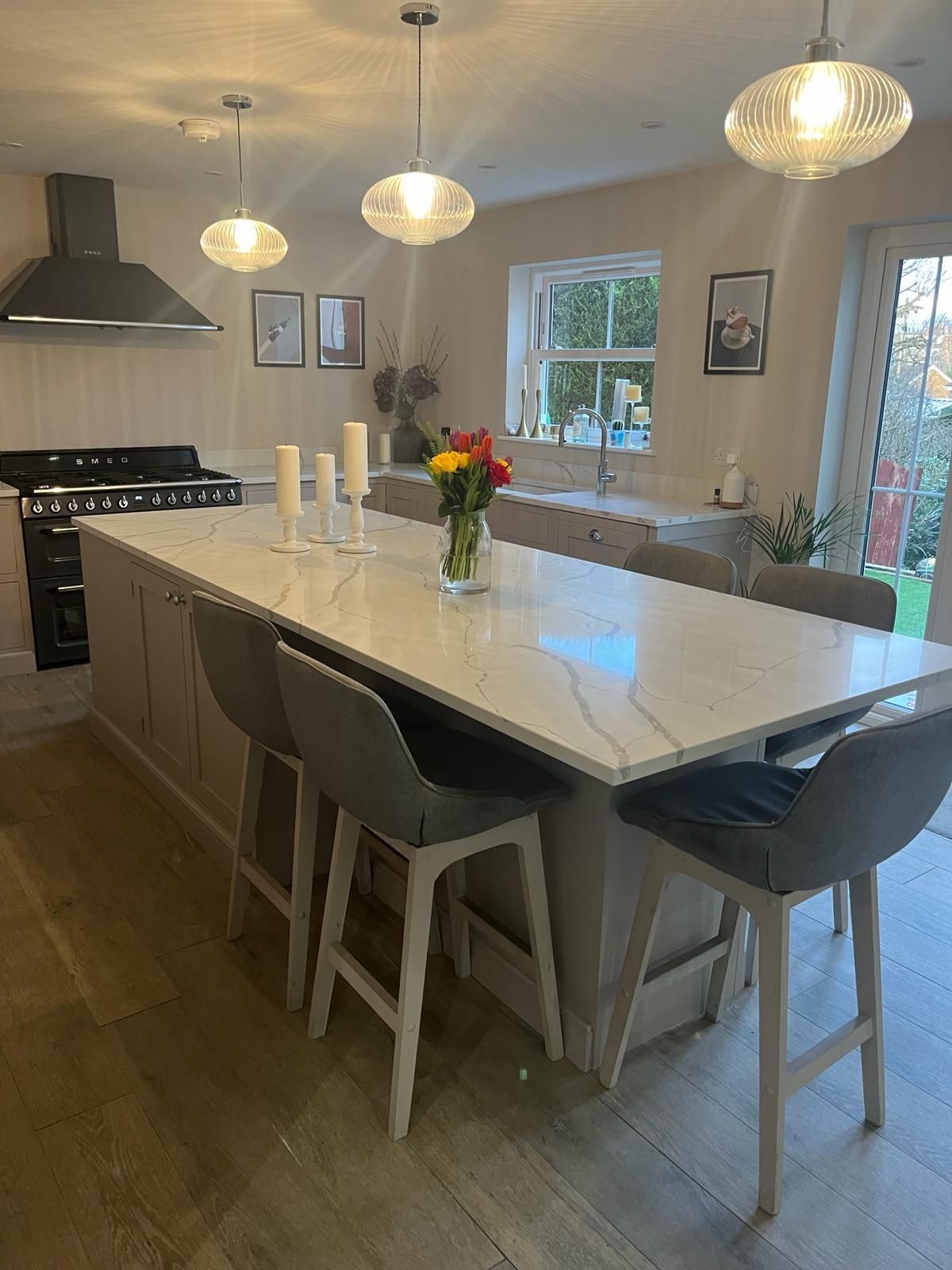 a kitchen with a large island and stools and a stove .