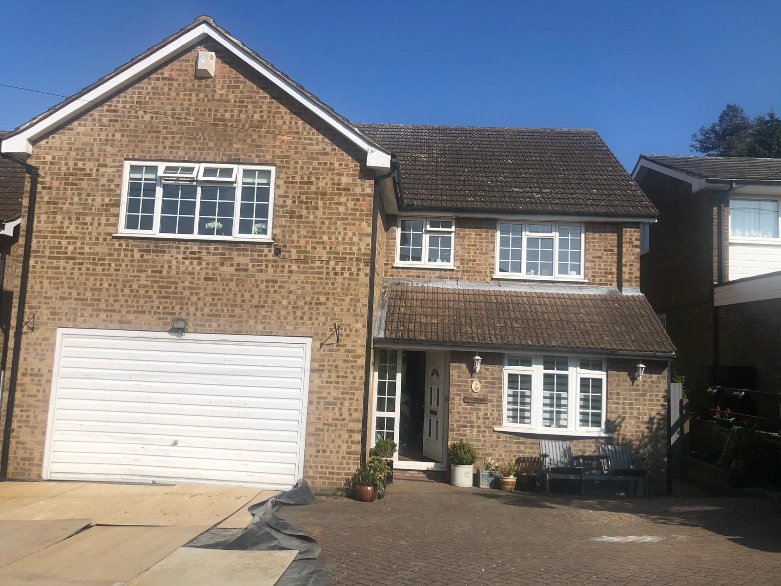 a large brick house with a white garage door and a driveway .