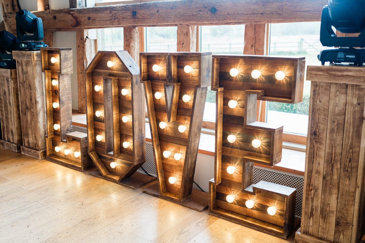 Large, illuminated rustic wooden marquee letters spelling 