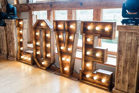 Large, illuminated rustic wooden marquee letters spelling
