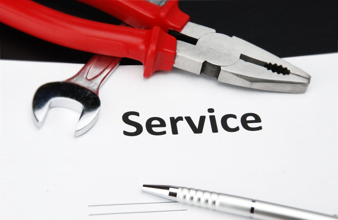 Red pliers and wrench on paper with the word 