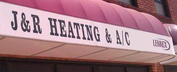Sign for J&R Heating & A/C with a burgundy and white awning and Lennox logo.