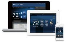 Laptop, tablet, and smartphone displaying a smart thermostat interface showing temperature.