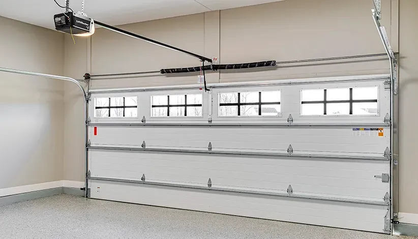White garage door with windows, open in a bright garage.