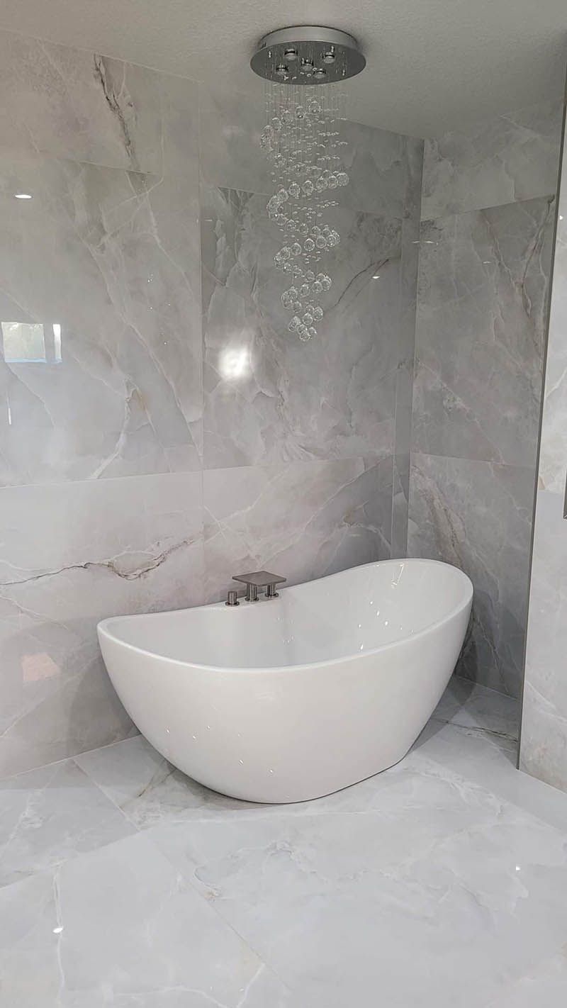 A white bathtub is sitting in a bathroom next to a shower.