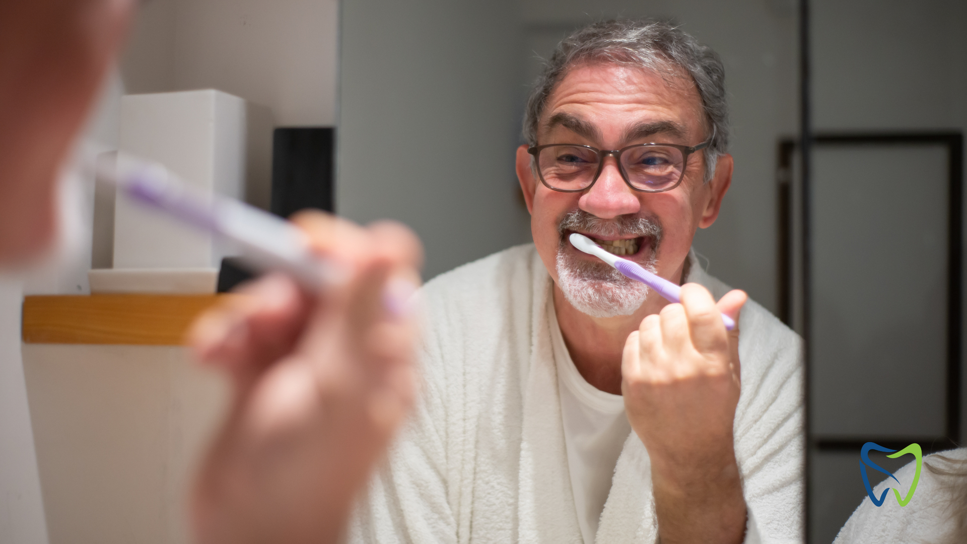 An older man is brushing his teeth in front of a mirror.