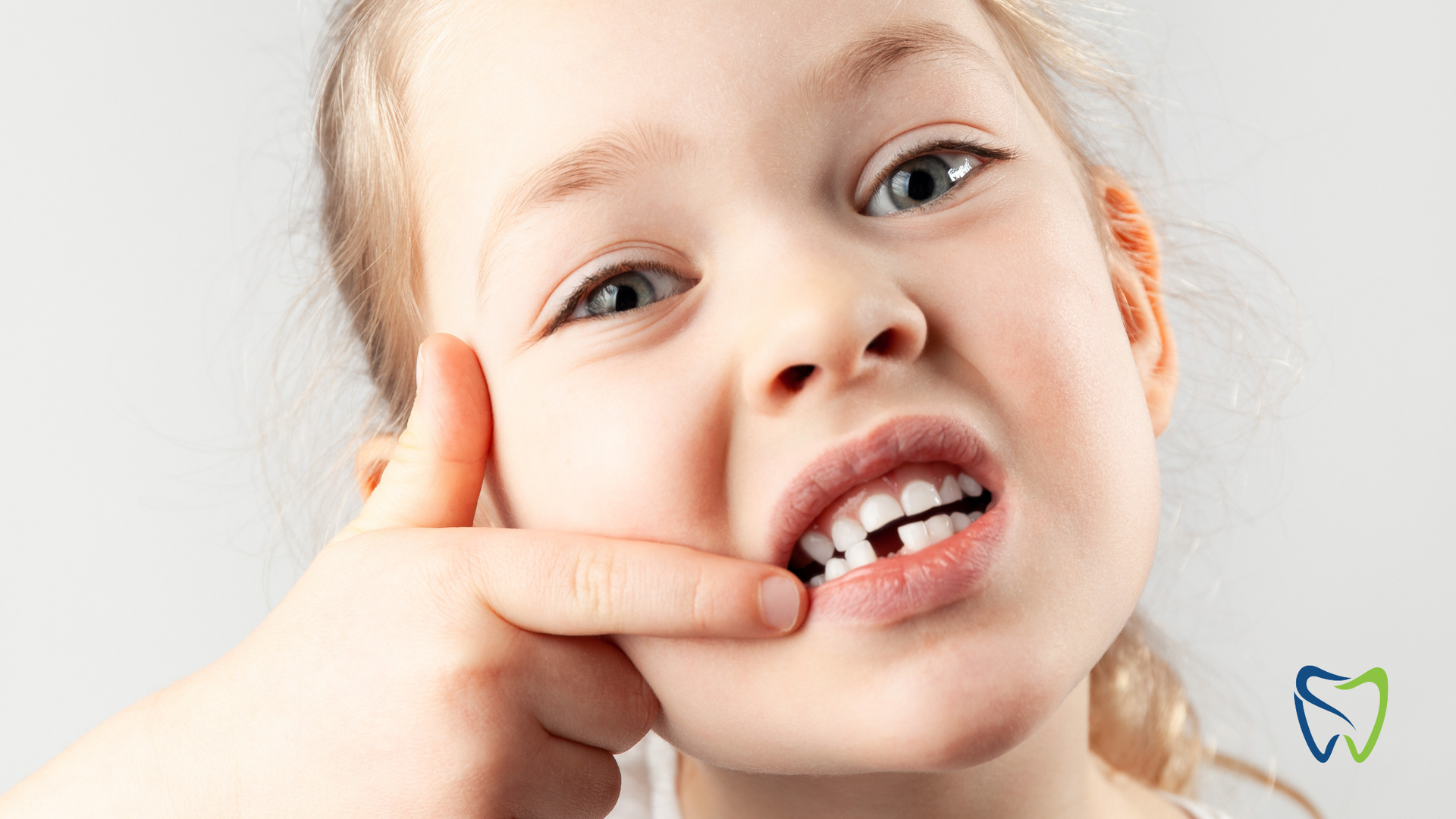 A little girl with a missing tooth is making a funny face.