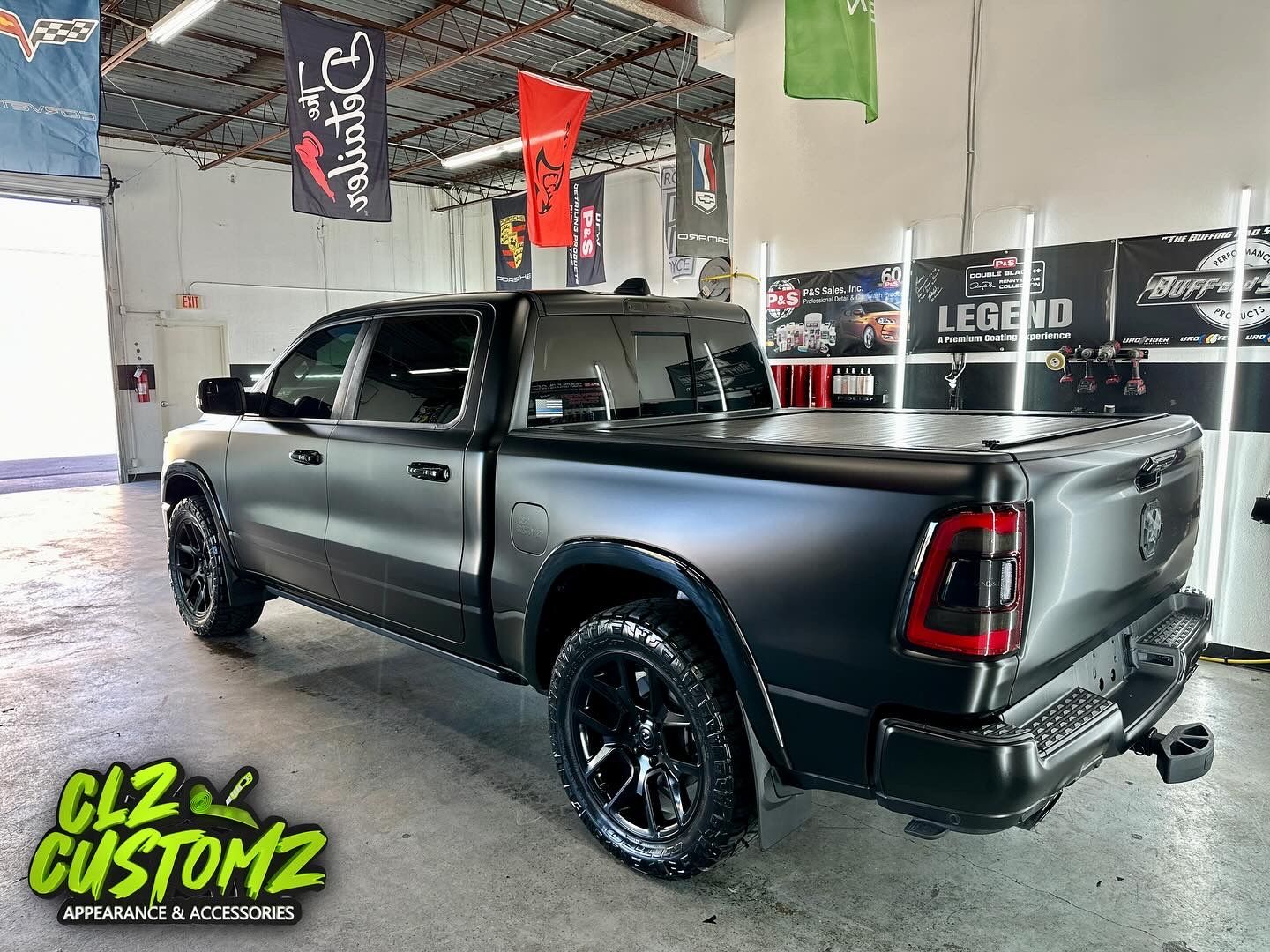 Black matte Ram pickup truck in a shop.