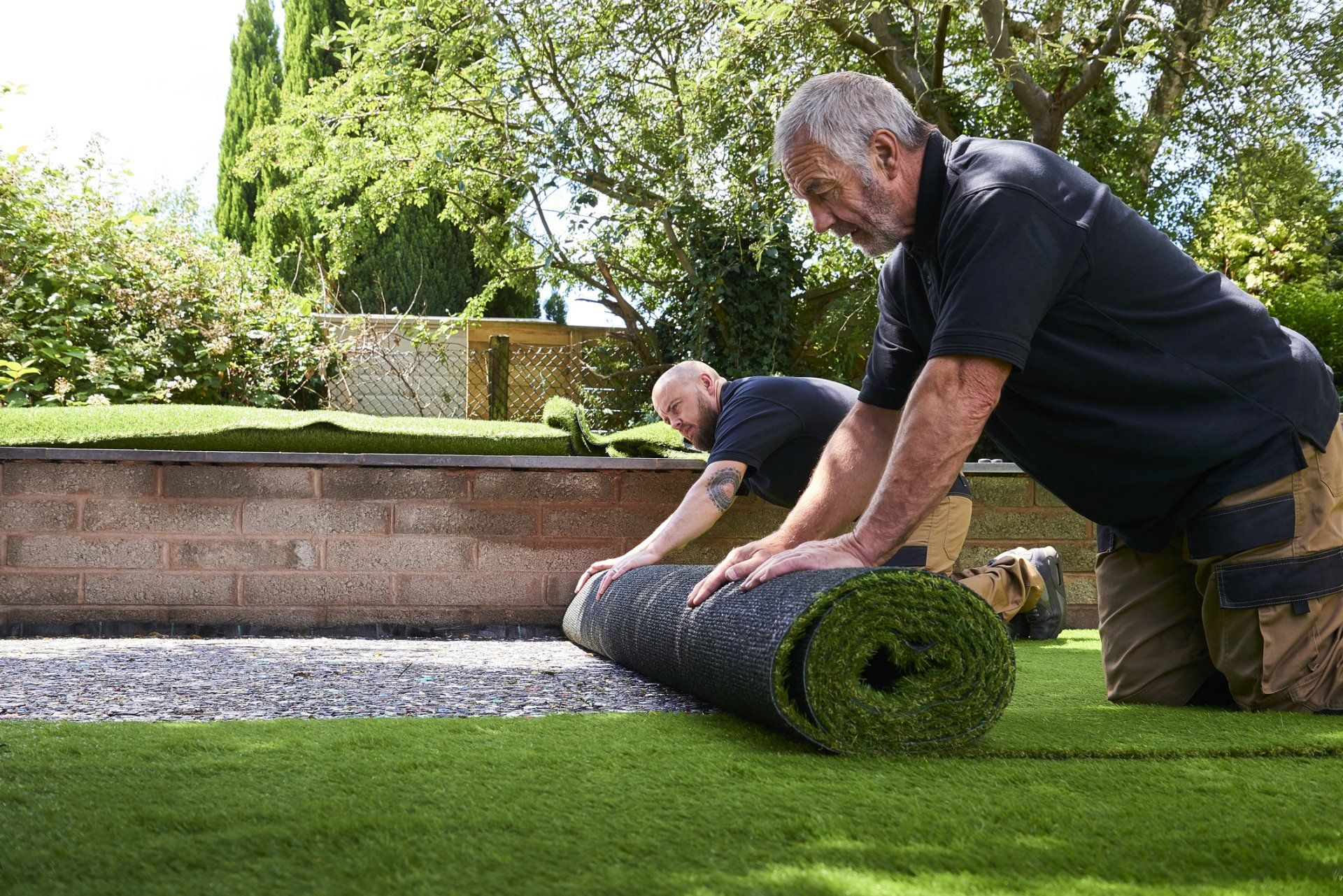 Two Workers Installing Artificial Grass - Plano, TX - AllTex Landscape & Construction