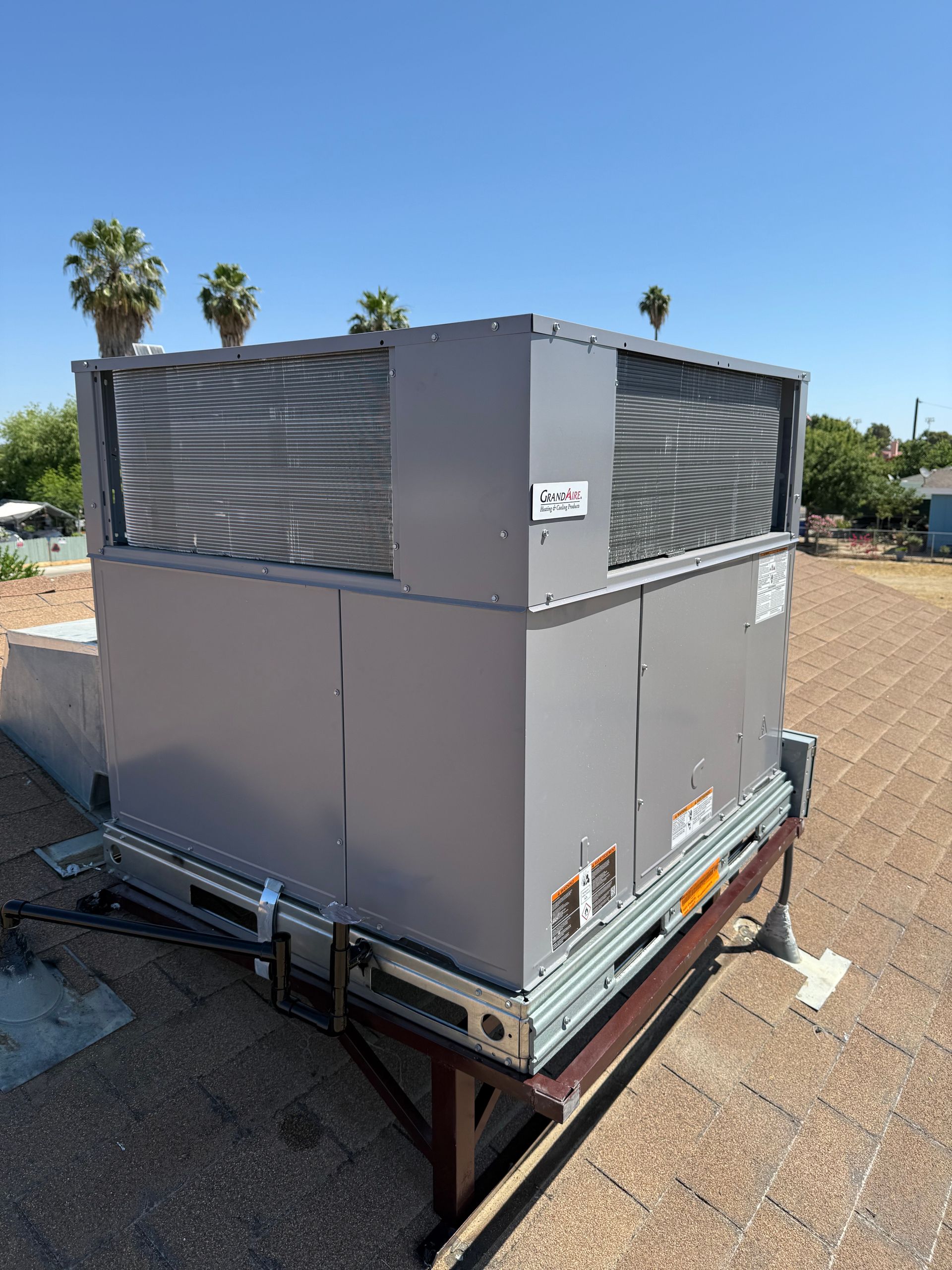 A large air conditioner is sitting on top of a roof.