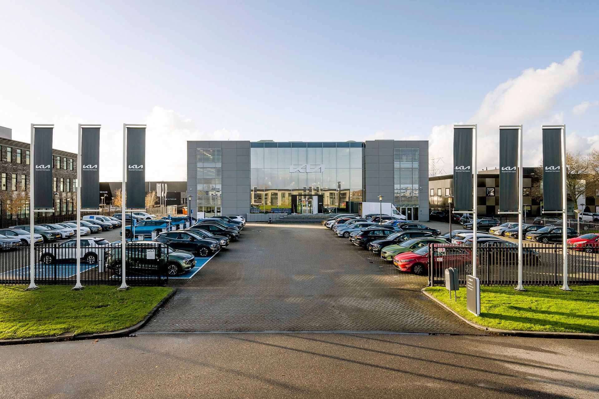 Een groot gebouw met veel auto's ervoor geparkeerd