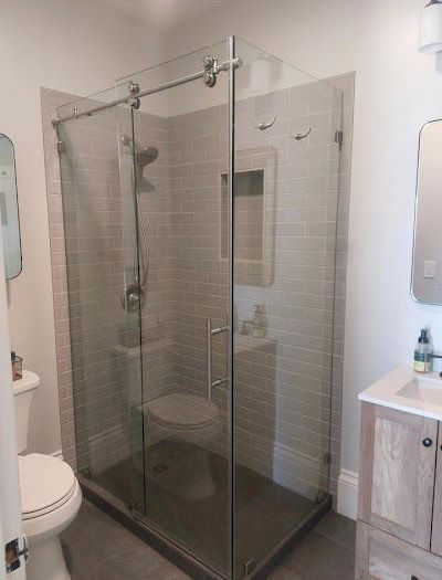 A bathroom with a toilet , sink and shower stall.