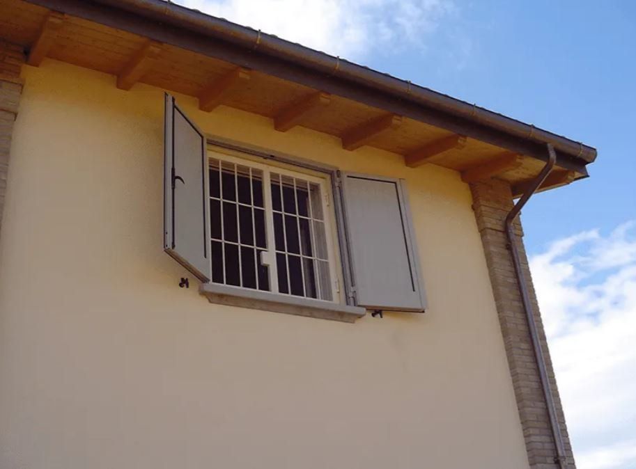 Finestra con persiane e inferriate