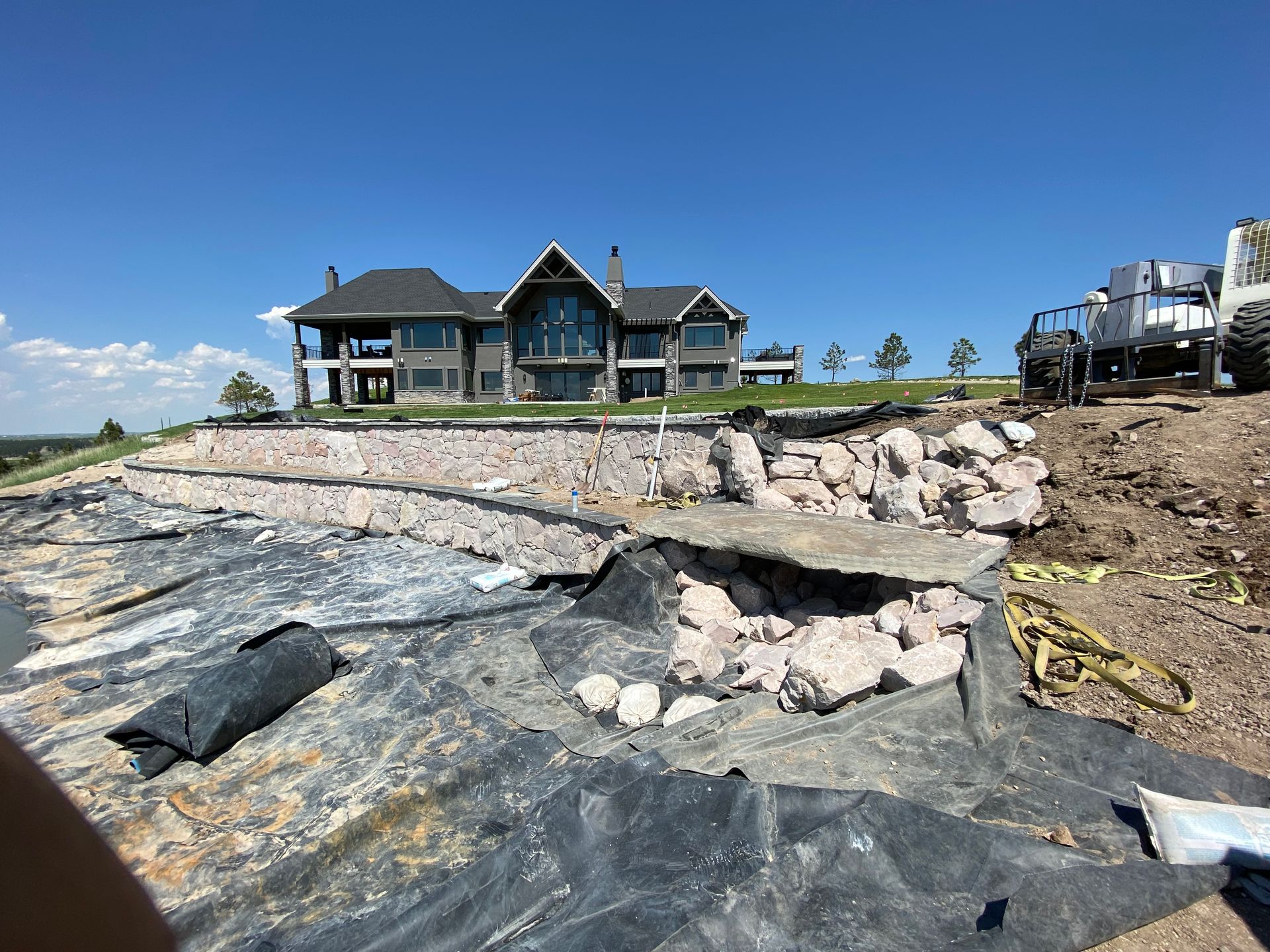 A large house is being built on top of a hill.