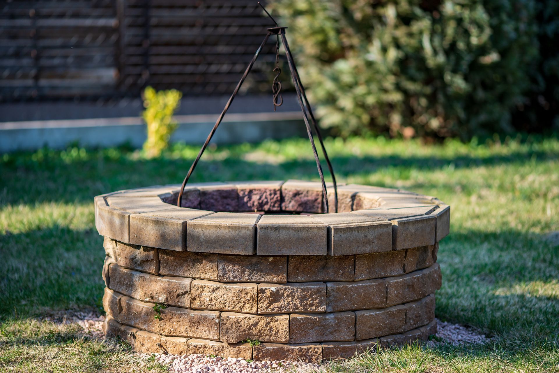 A fire pit is sitting in the middle of a lush green yard.