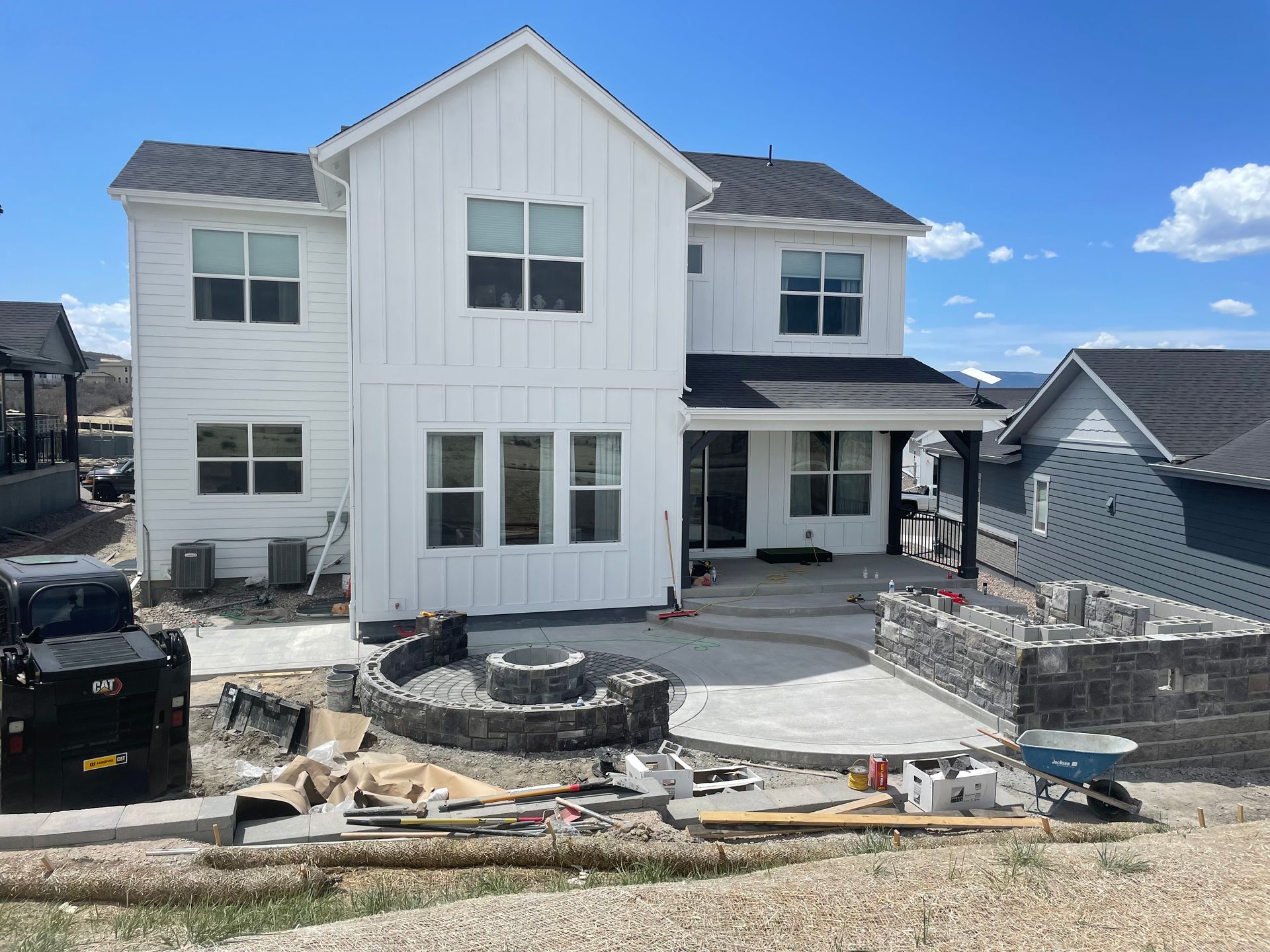 A large white house is being built in a residential area.