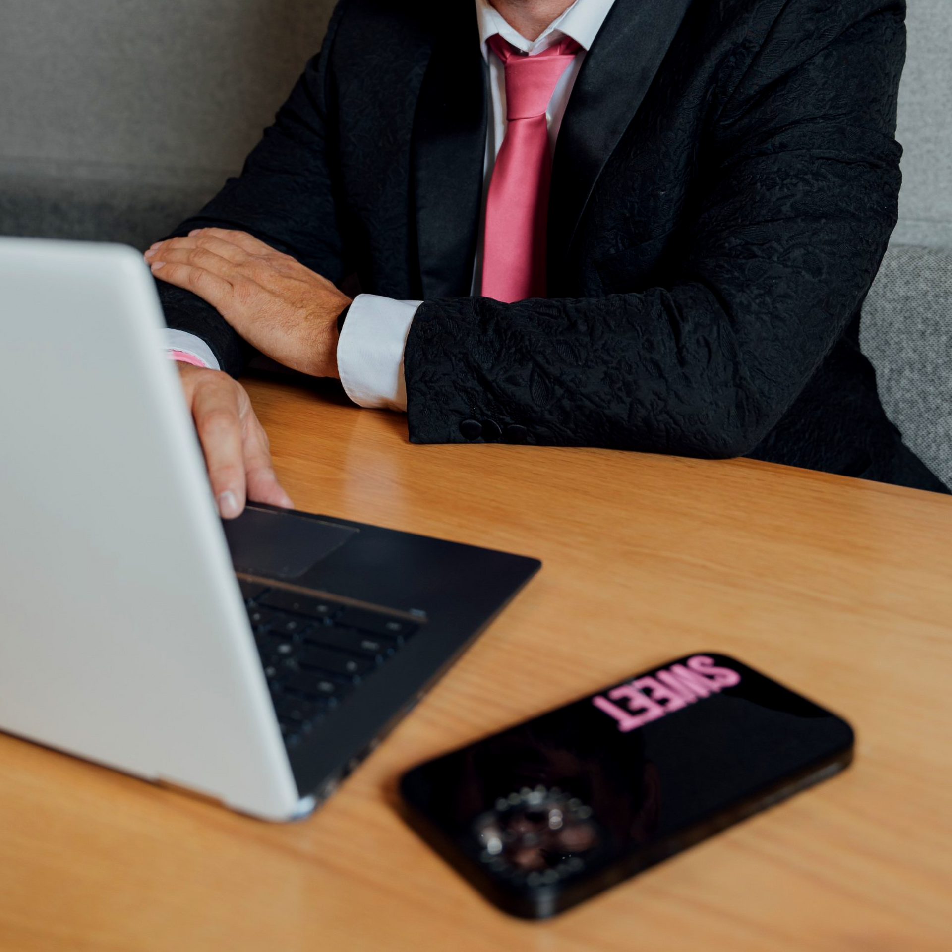 Person in suit with laptop and phone labeled