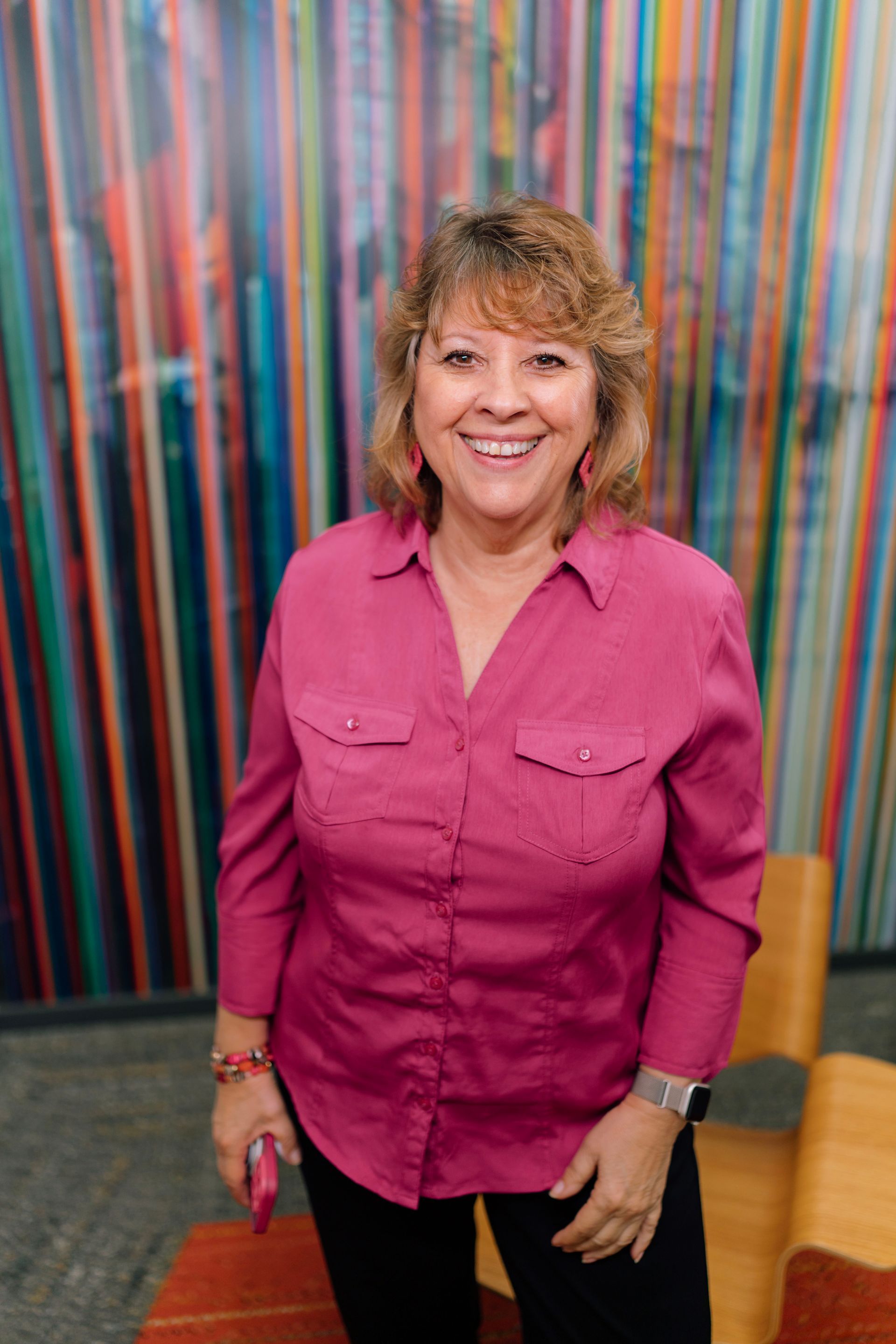 a woman is standing in a kitchen holding a bottle of wine .