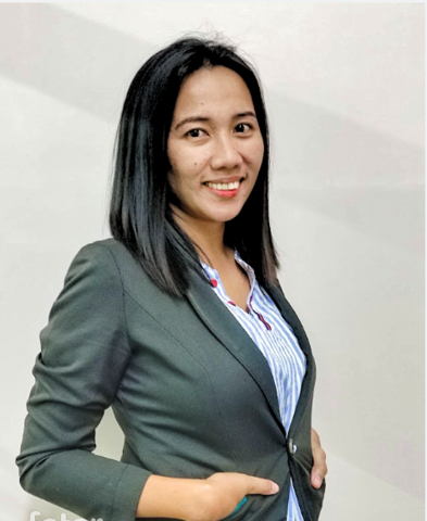 A woman in a suit and striped shirt is smiling for the camera.