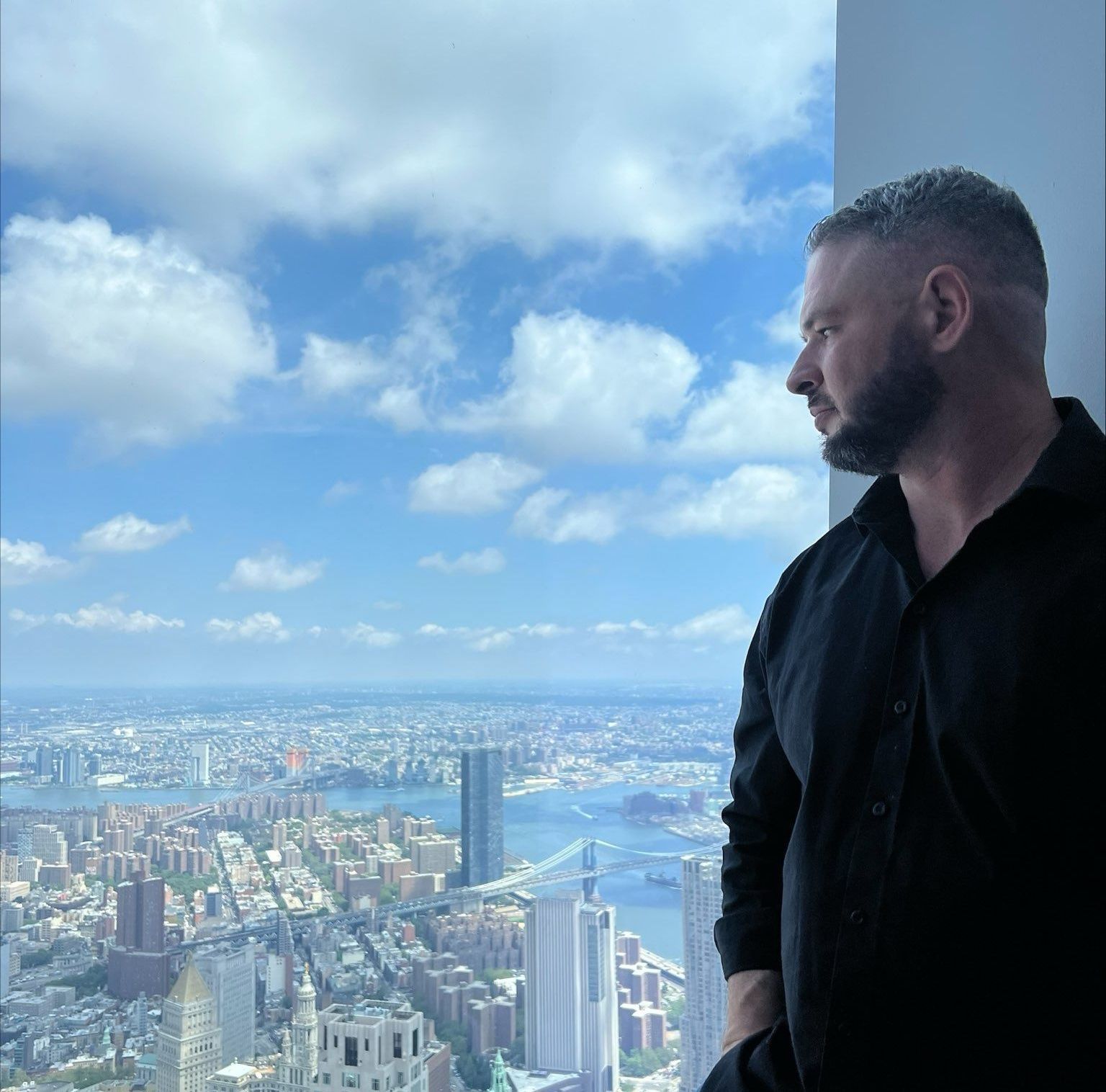 a man is standing in front of a window overlooking a city .