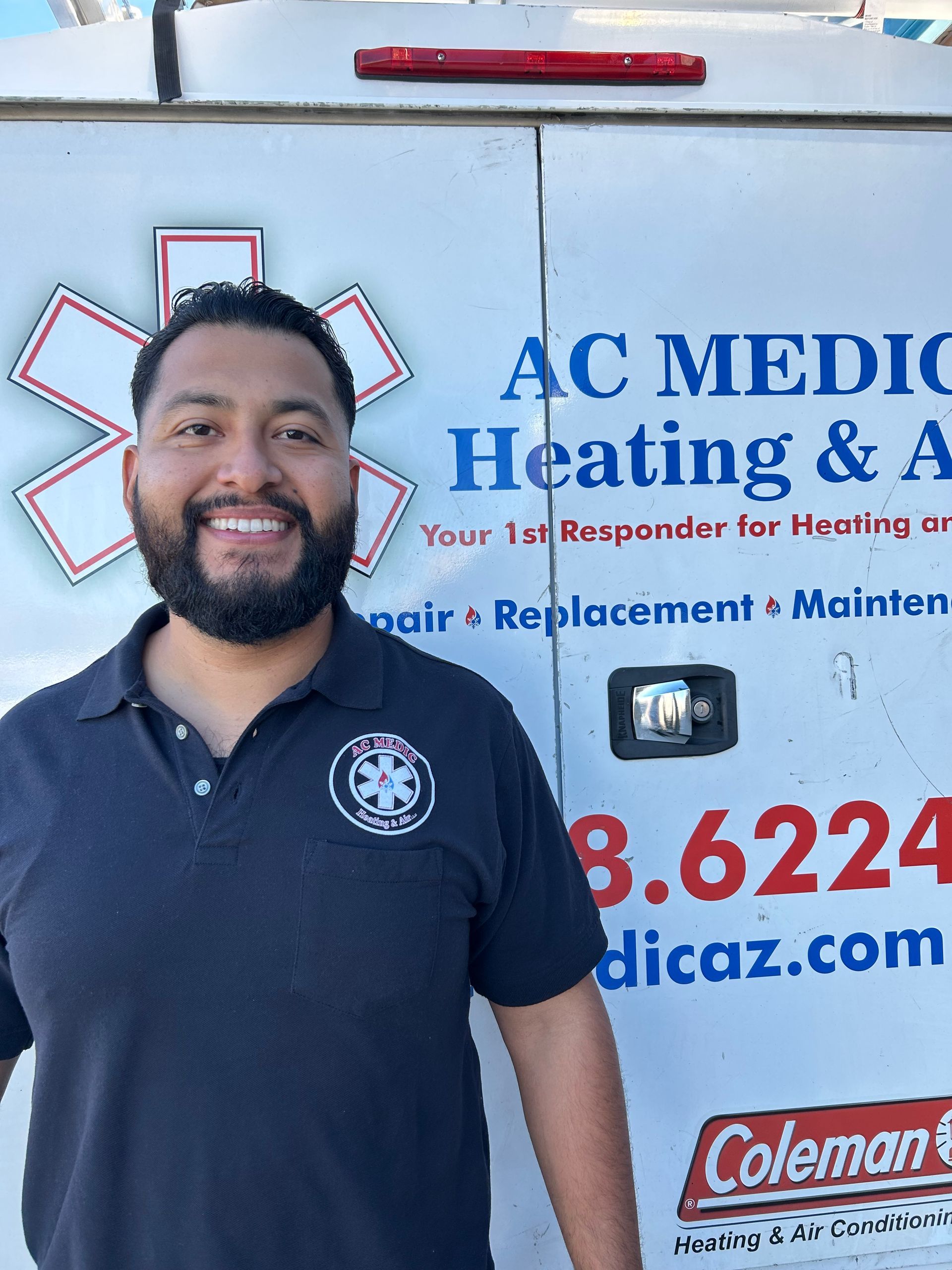 Man in a polo shirt smiles in front of an AC Medic van; logo features a star of life.