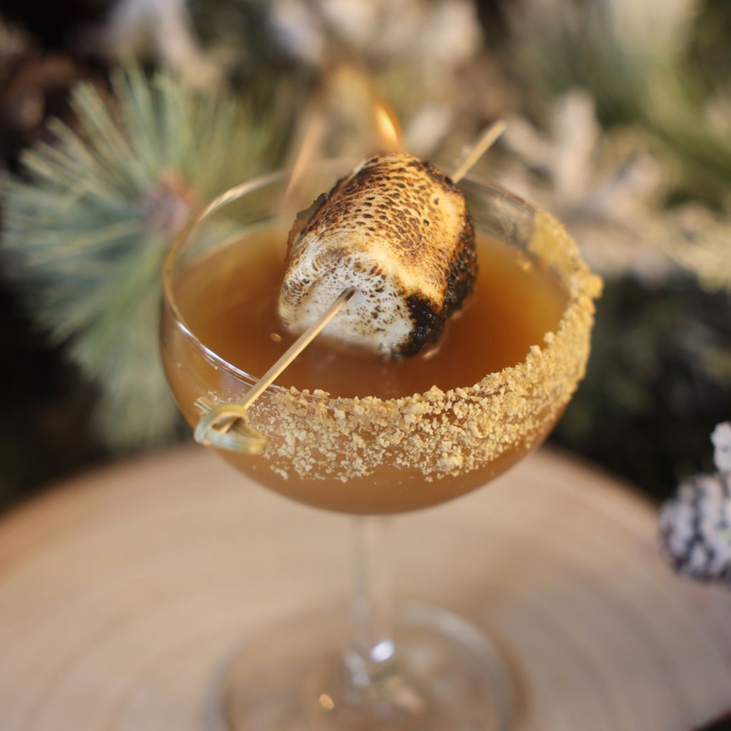 a martini glass with a charred marshmallow 

