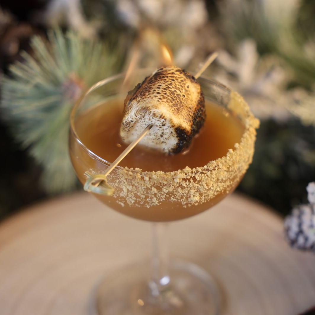 a martini glass with a charred marshmallow 
