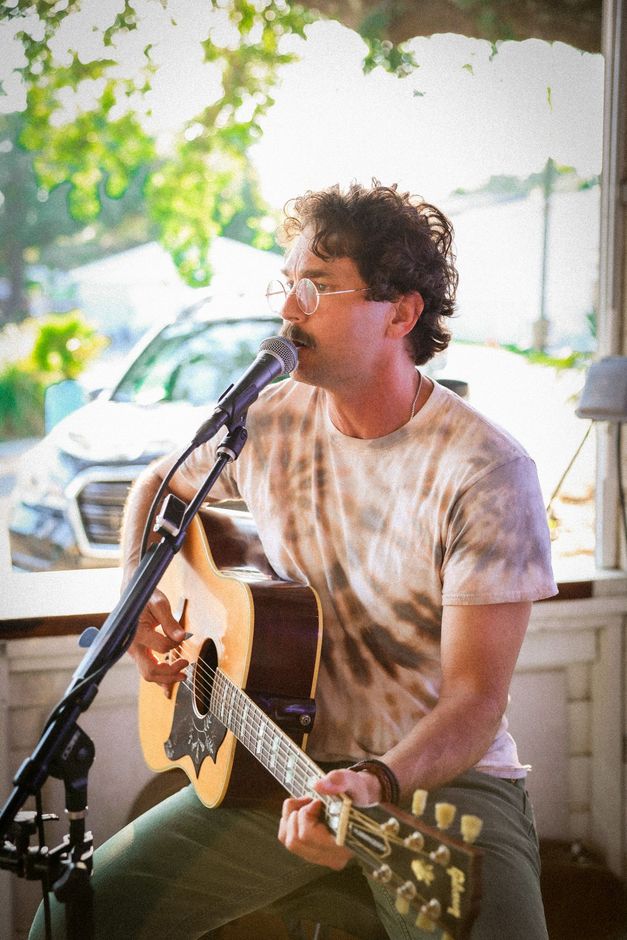A man is singing into a microphone while playing a guitar.