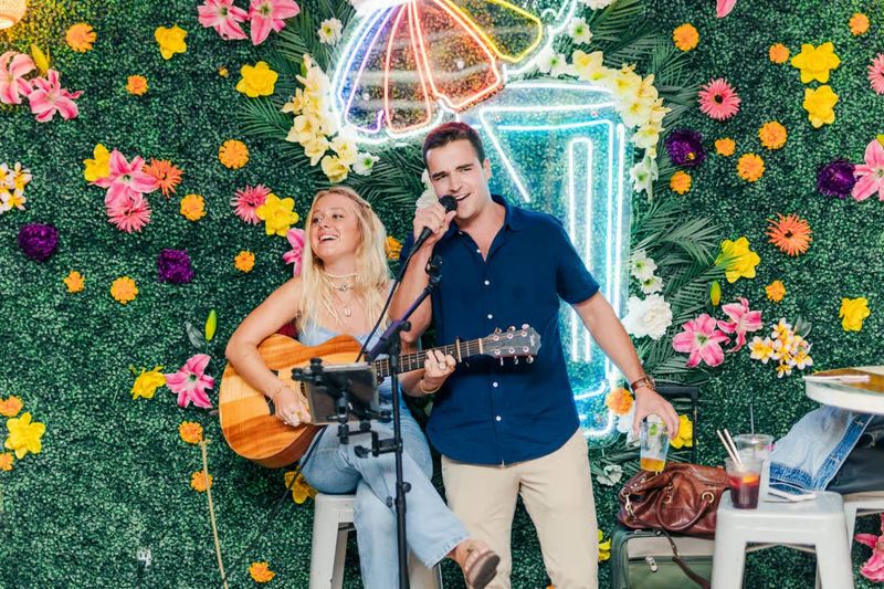 A man and a woman are playing guitars and singing into microphones.