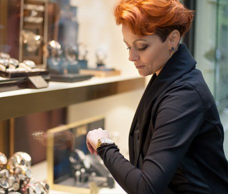 Specialty Watches — Woman Looking in a Shop Window with Watches in Madison, WI