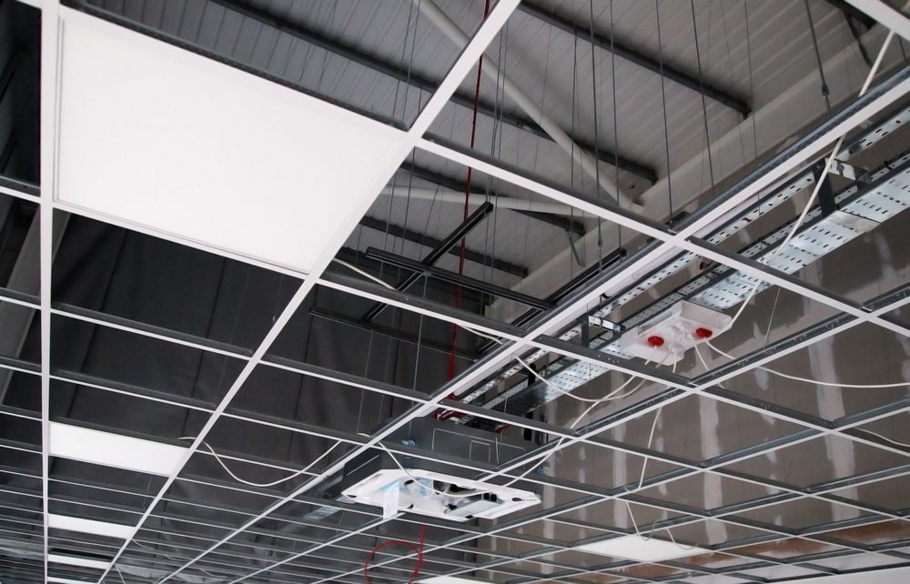 A ceiling with a lot of wires hanging from it.