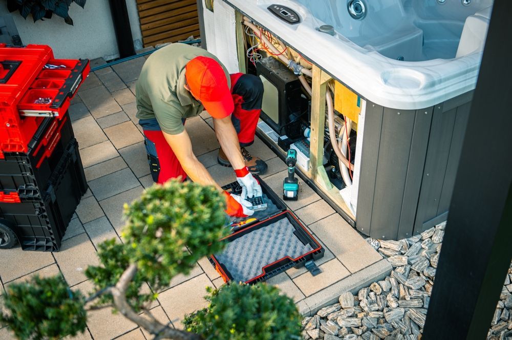 A man is working on a hot tub on a patio.