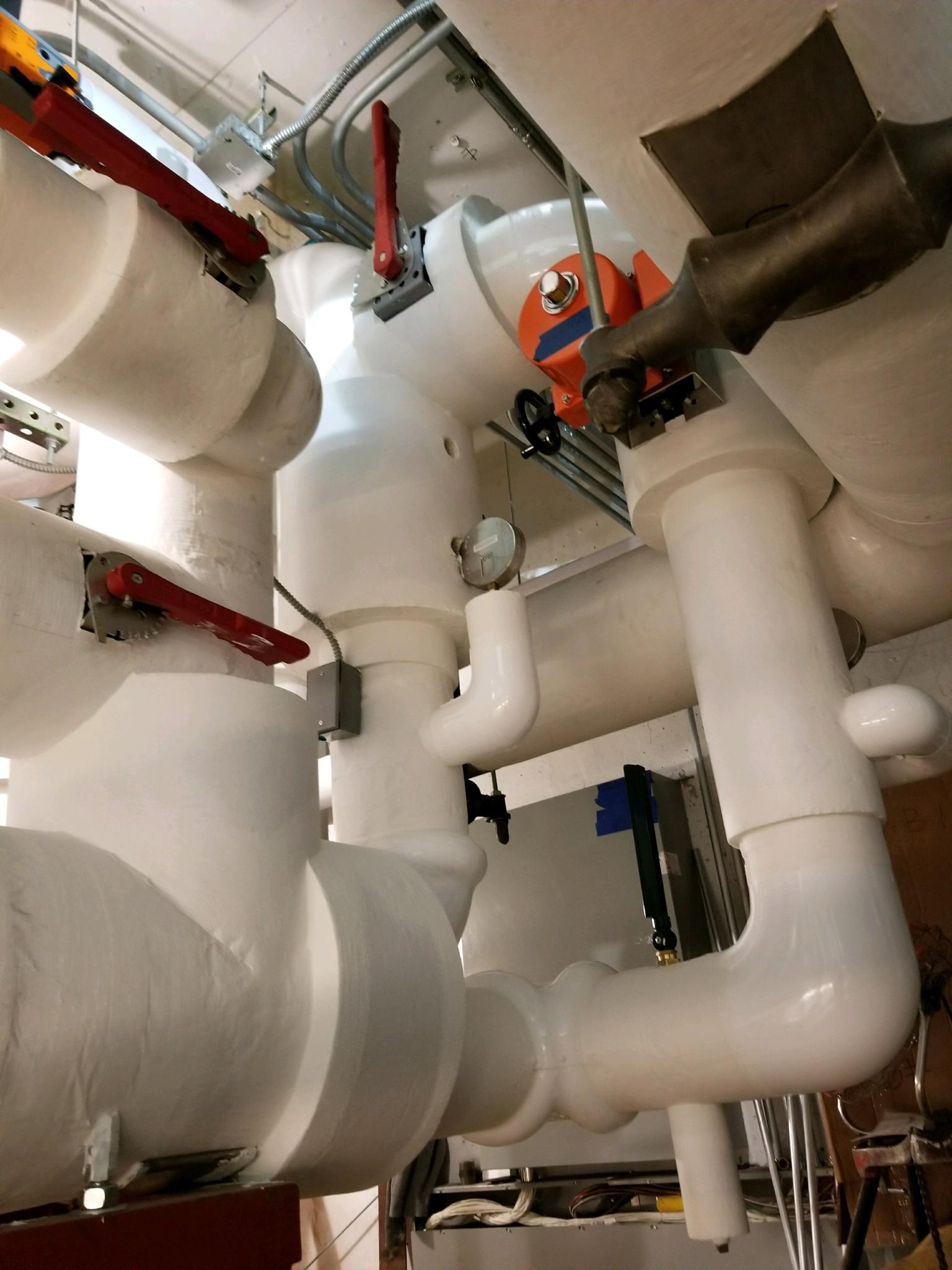 white insulated pipes are lined up in a room